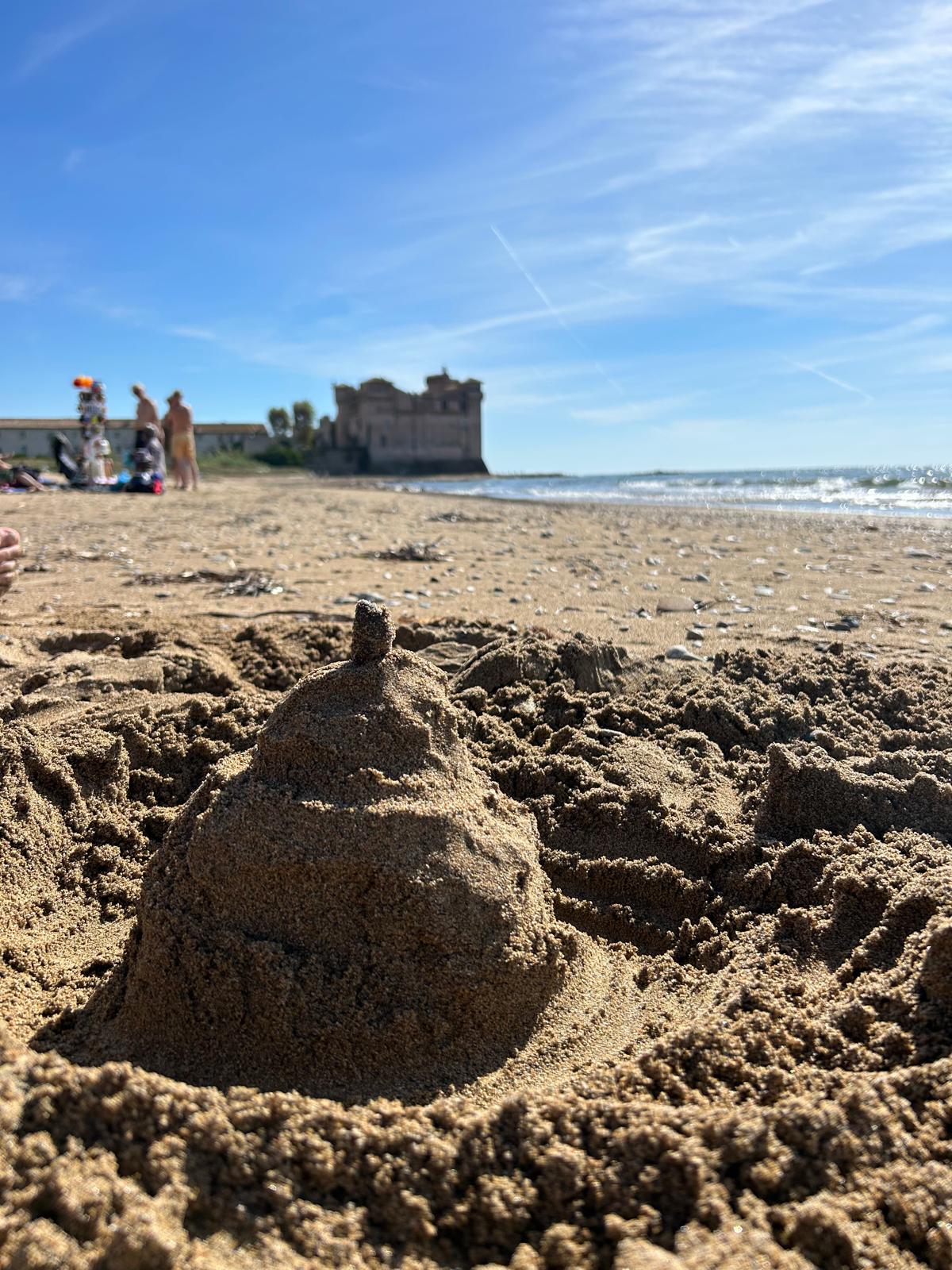 Sandcastle on the beach with Santa Severa Castle in the background